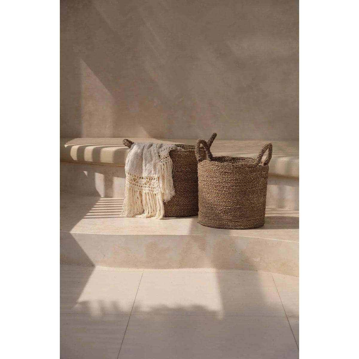 Alt Tag: Handgeweven zeegras manden met handvatten, perfect voor wasgoed of planten. Tijdloos design in een natuurlijk interieur. Set van vier.