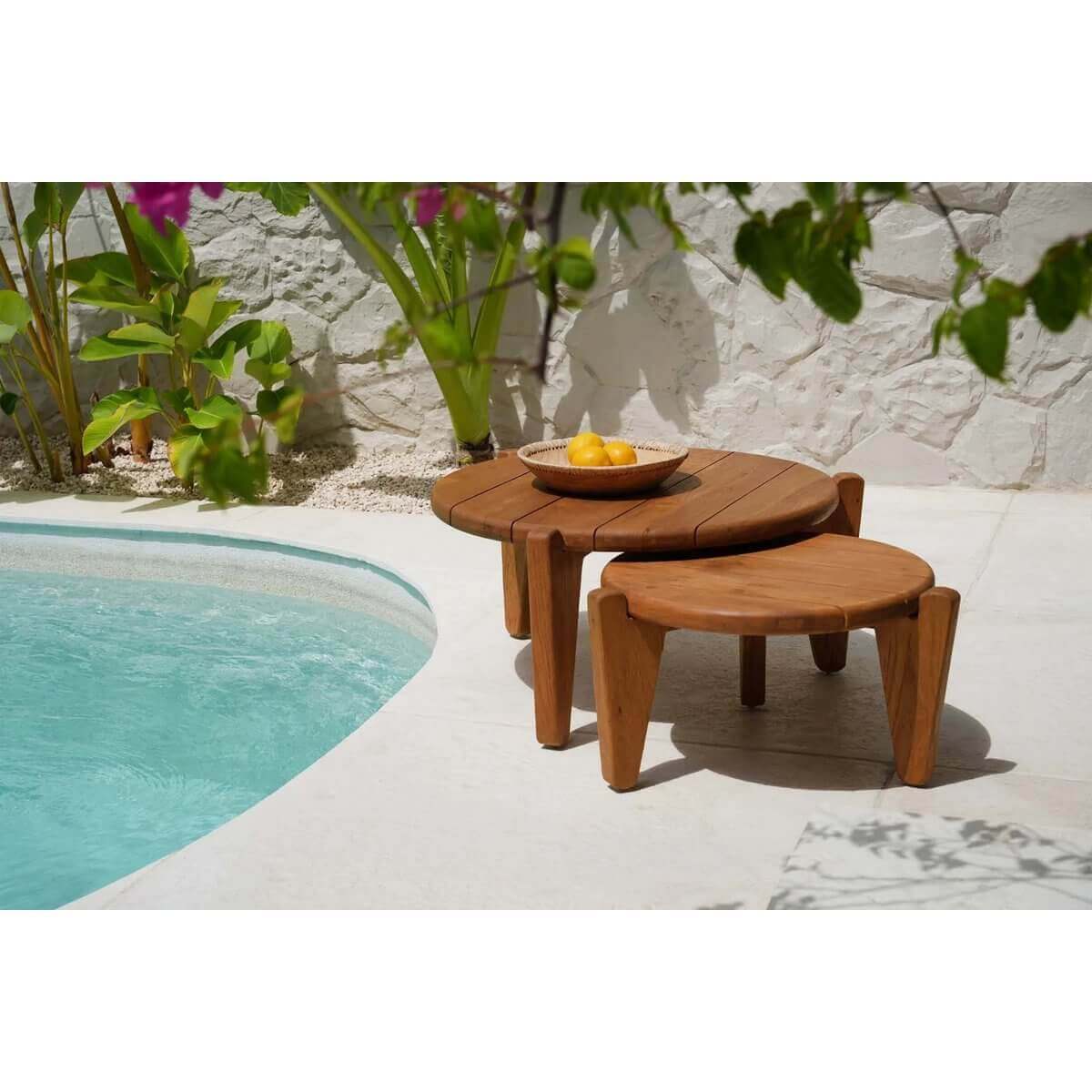 De unieke Seseh-salontafel van teakhout met modern ontwerp, perfect voor terras of tuin, naast turquoise zwembad in zonnige setting.