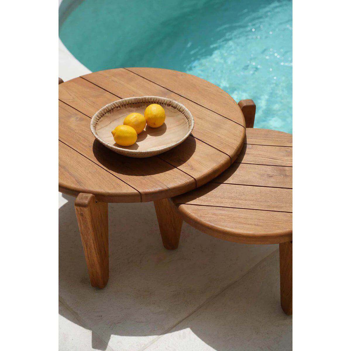 "De Seseh salontafel in teak bij zwembad, met citroenen op een schaal. Ideaal voor tuin of balkongebruik."