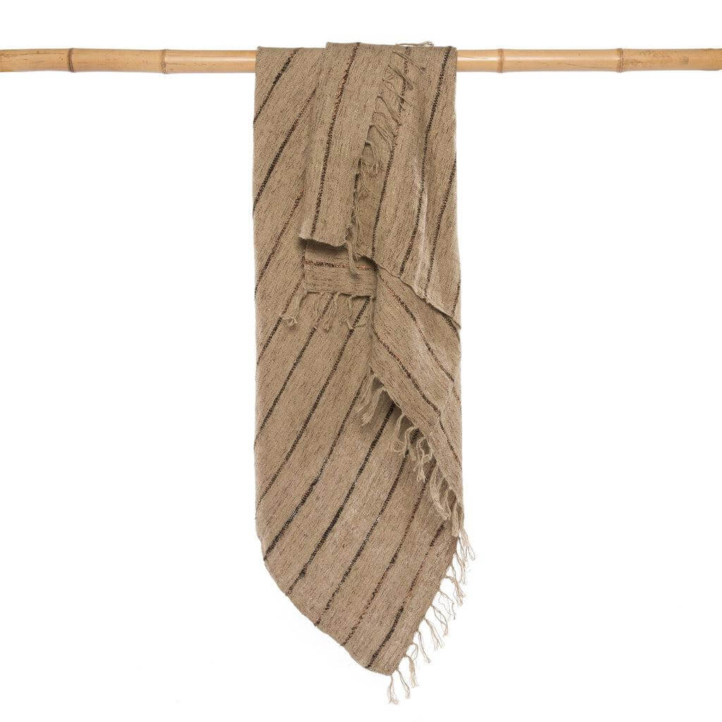 Luxe handgeweven katoenen plaid met wafeleffect en franjes in beige en zwart, perfect voor een warme sfeer in huis.