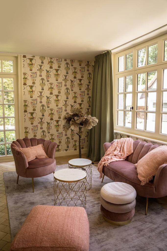 Stijlvolle woonkamer met roze interieur en De Sil vous Plaid in zalm roze op de bank, voor een gezellige en warme sfeer.