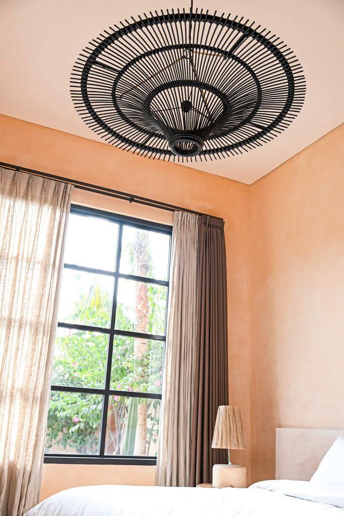 De Sky Hanglamp Zwart XL in slaapkamer, rotan kunstwerk aan plafond, elegante uitstraling, moderne interieurdecoratie.