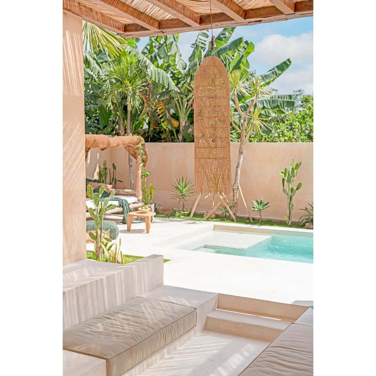 Rotan hanglamp De Squid Naturel L in een bohemian tuinsetting met zwembad en tropische planten