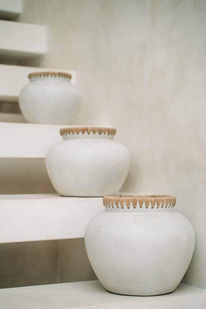 Drie terracotta vazen met raffia detail op trap, ideaal voor droogbloemen, geen waterdicht, perfecte kuststijl toevoer voor elke ruimte.