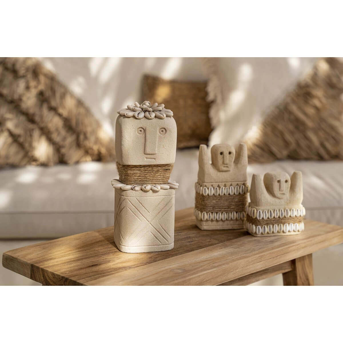 Handgemaakte Sumba-steenbeelden van zandsteen uit Indonesië, decoratief geplaatst op een houten tafel in een gezellige kamer.