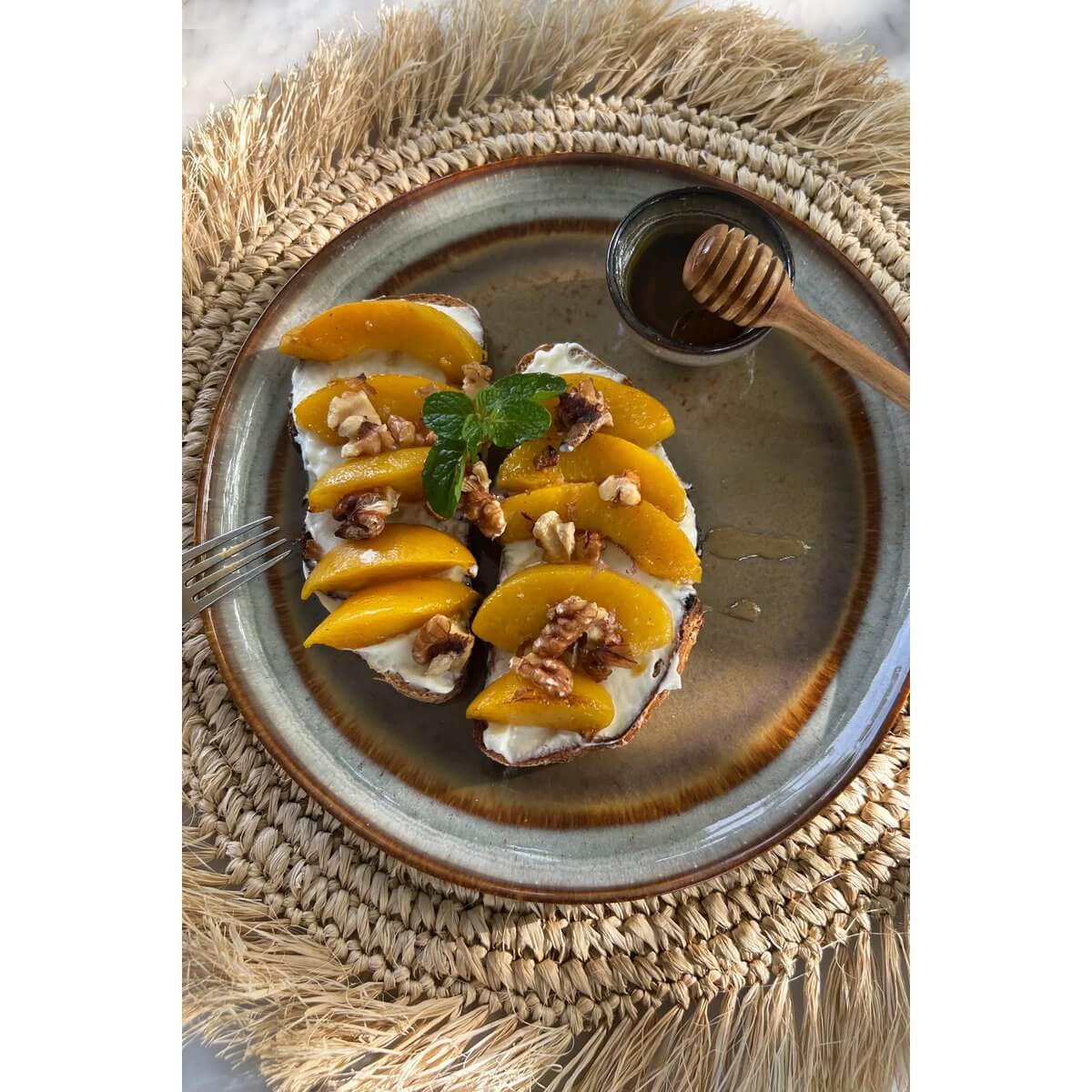 De Teakwortelhoningroller met een Bohemian twist, gepresenteerd op een handgemaakt bord met honing, walnoten en perzikpartjes. Perfect voor stijlvolle gastvrijheid.