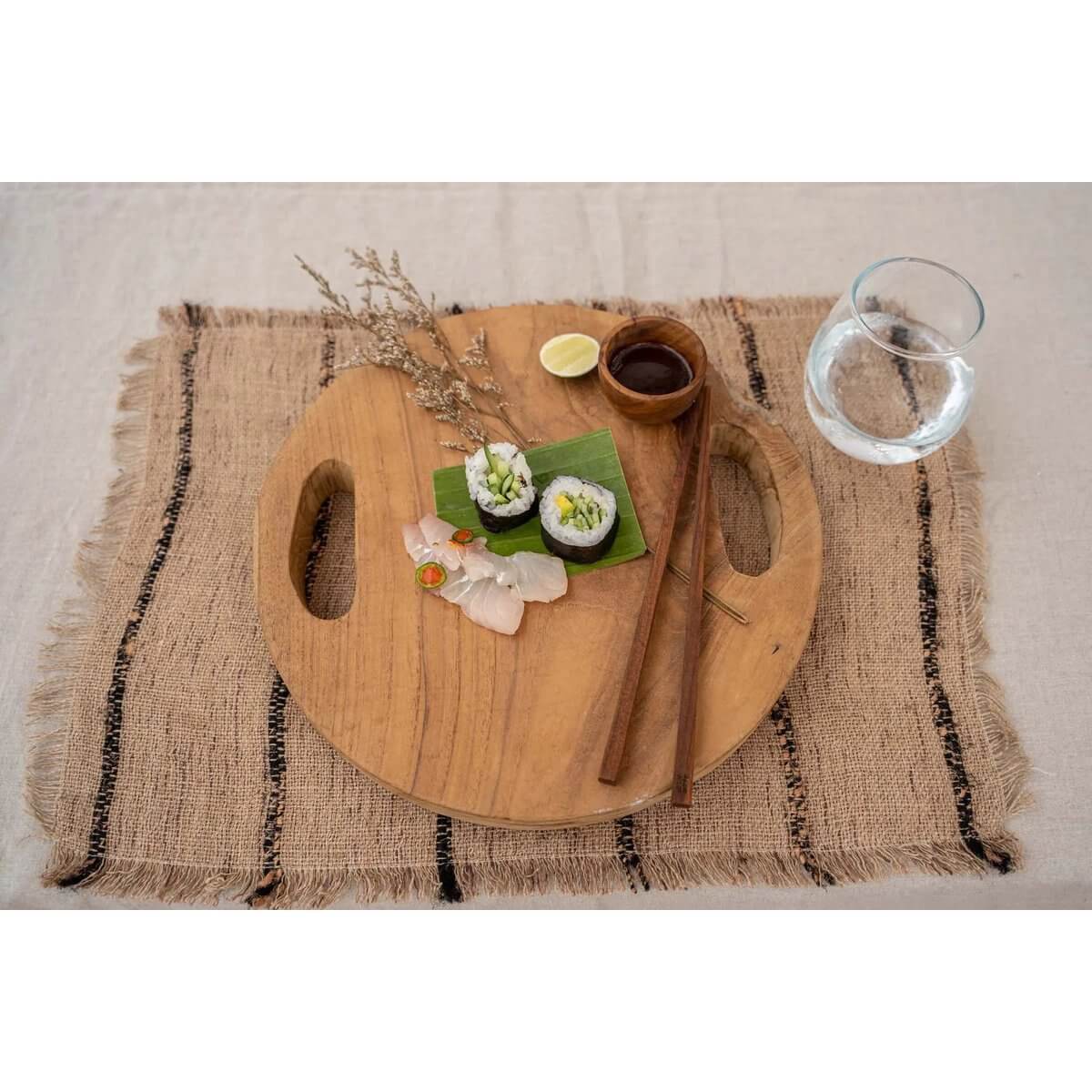 Bohemian teak salt holder on rustic round wooden platter with sushi, perfect for a natural table setting and enhancing food presentations.