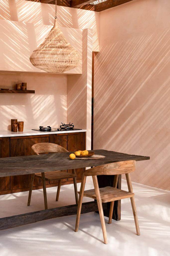 Elegante eetkamer met De Teluk eetkamerstoel van hergebruikt teakhout, naast een stijlvolle houten tafel en moderne keuken.