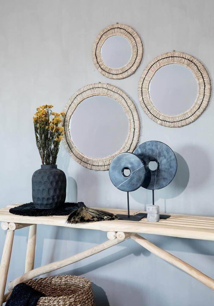 Stijlvolle zwarte vaas De Trendy Vaas met gedroogde bloemen op houten tafel, omringd door decoratieve spiegels.