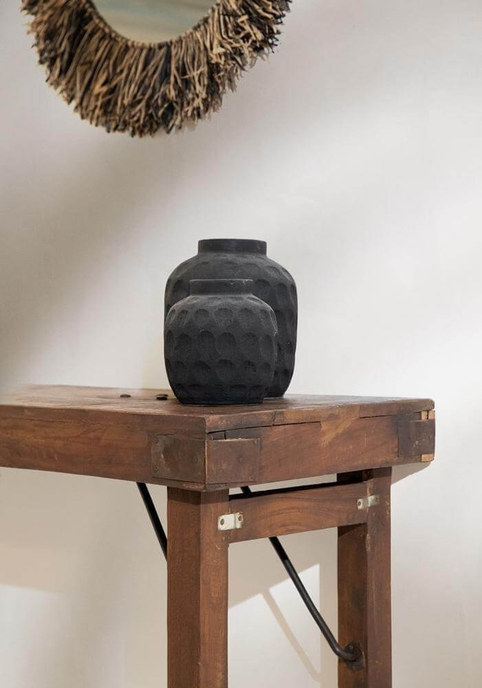 Zwarte terracotta vaas met eigentijds patroon op houten tafel, ideaal voor droogbloemen, hoogte 22 cm.
