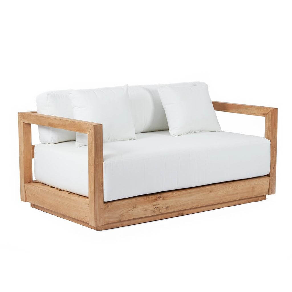 De Umalas tweezitsbank van gerecycled teakhout met sunbrella kussens, perfect voor binnen en buiten, op een witte achtergrond.