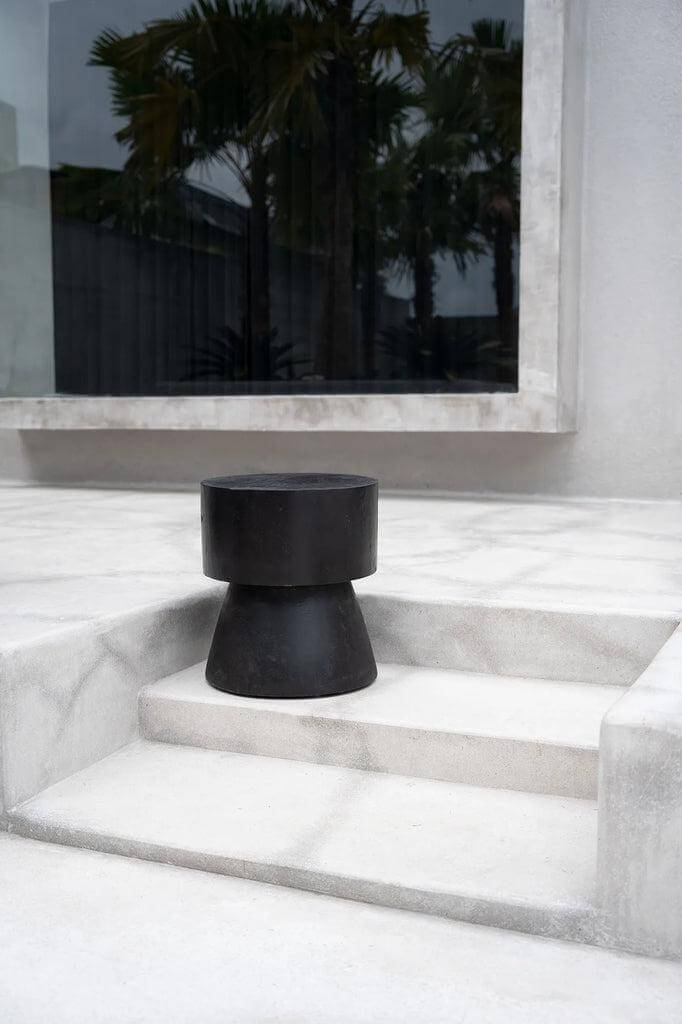 Zwarte Warmi kruk op terras, biedt strakke lijnen en futuristisch ontwerp, ideaal als kruk of bijzettafel in elk interieur.