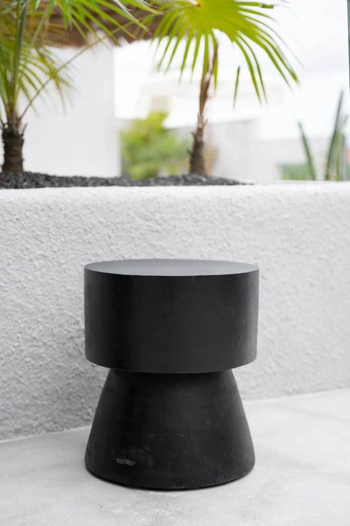 Zwarte Warmi kruk van suarhout met futuristisch design voor binnen en buiten gebruik, geeft een stijlvol accent aan elk interieur.