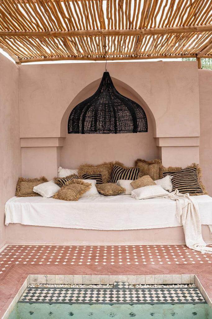 Alt Tag: Zwarte XL rotan hanglamp boven boho chic loungehoek bij zwembad, perfect voor binnen of overdekte buitenruimtes.