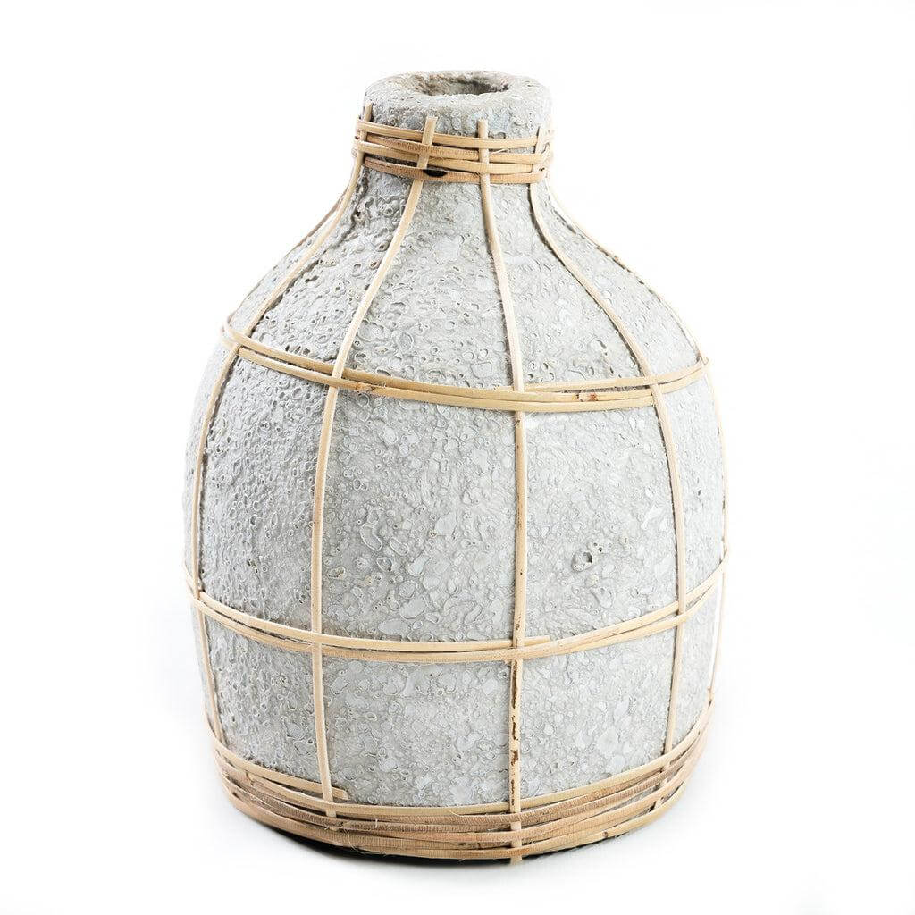 De Whoopy Vaas - Betongrijs Naturel S met rotan detail, perfect voor droogbloemen en decoratie. Niet waterdicht, hoogte 19 cm.