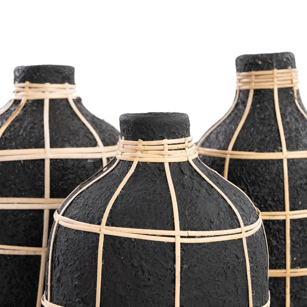 Drie zwarte vaasjes met rotan detail, perfect voor droogbloemen, in een natuurlijke kuststijl.