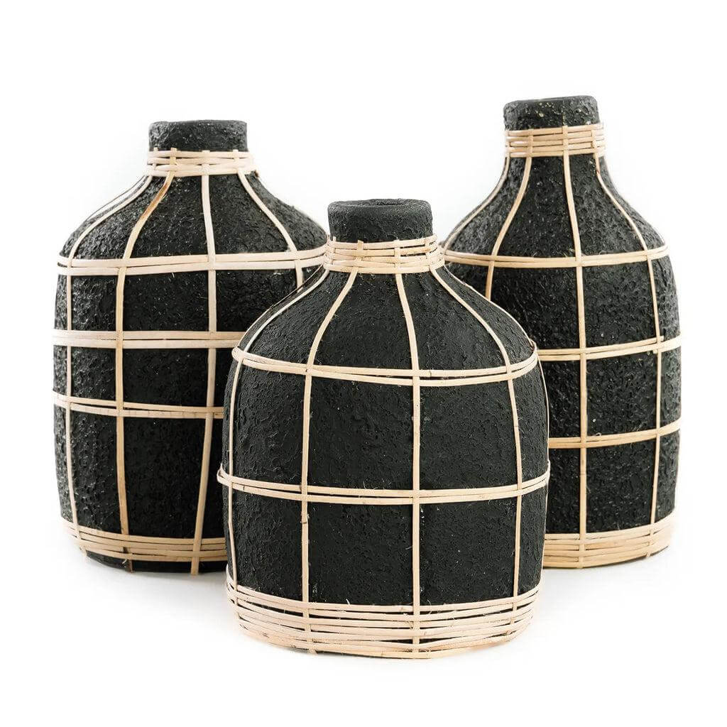 Drie zwarte terracotta vazen met rotan details, perfect voor droogbloemen decoratie in een kuststijl interieur.