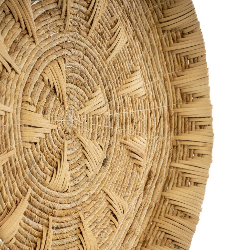 Detail van De Xolo Muurdecoratie, rond kunstwerk van bananenblad en rotan, met natuurlijke tinten en geweven ontwerp.