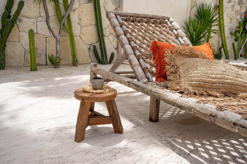 De Yatai kruk in tuin met ligstoel, natuurlijke uitstraling en teakhout accenten, perfect voor buitenruimte. Decoratieve styling.