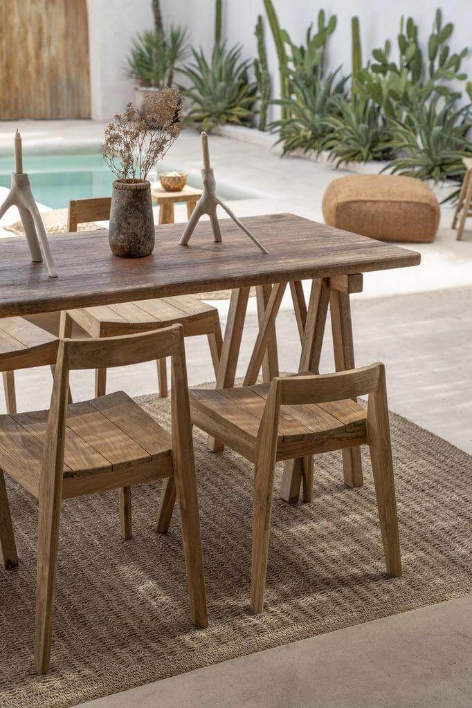 De Ydra eetkamerstoel in een elegante buitenruimte met gerecycled teakhout en minimalistisch design, perfect voor binnen en buiten.