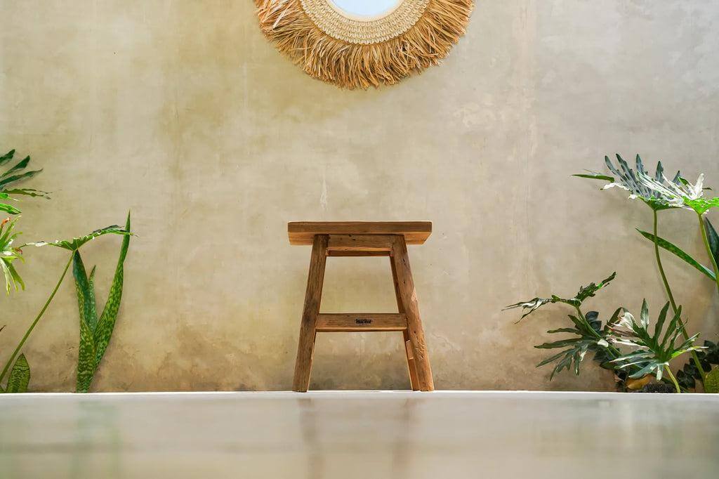 Rustieke Yoke kruk van gerecycled teakhout in een natuurlijke omgeving, perfect voor duurzaam en stijlvol wonen.