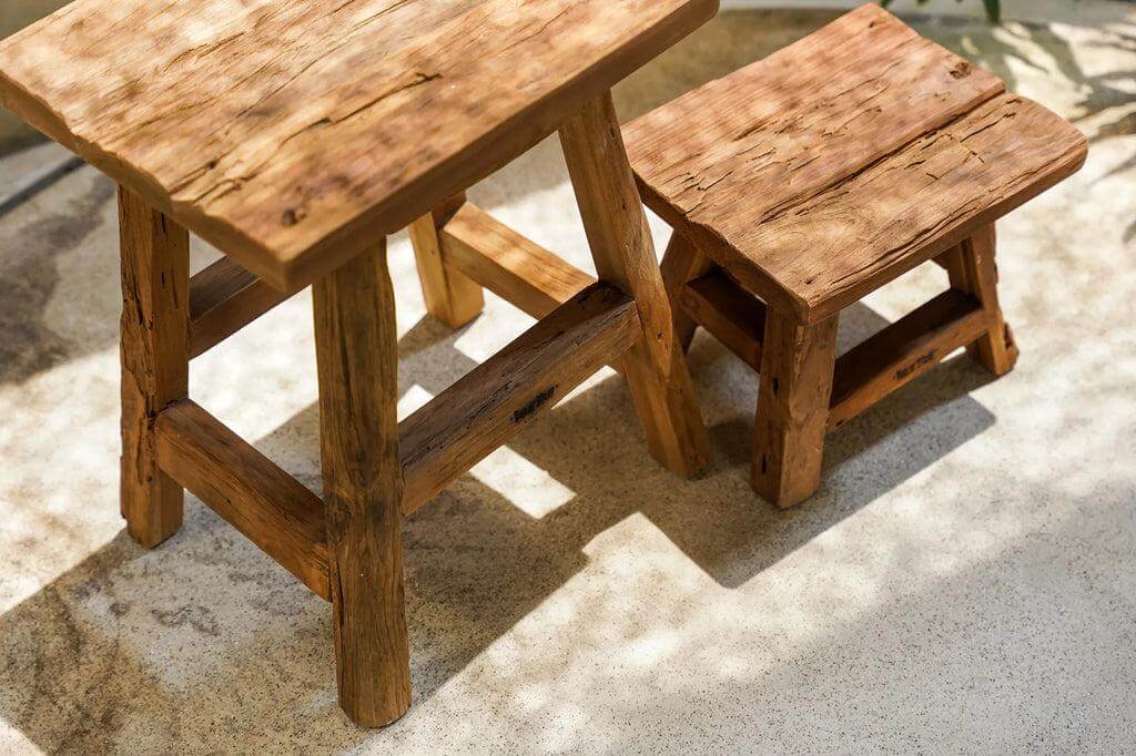 De Yoke kruk in twee maten, handgemaakt van gerecycled teakhout met rustieke afwerking, perfect voor stijlvolle en duurzame inrichting.