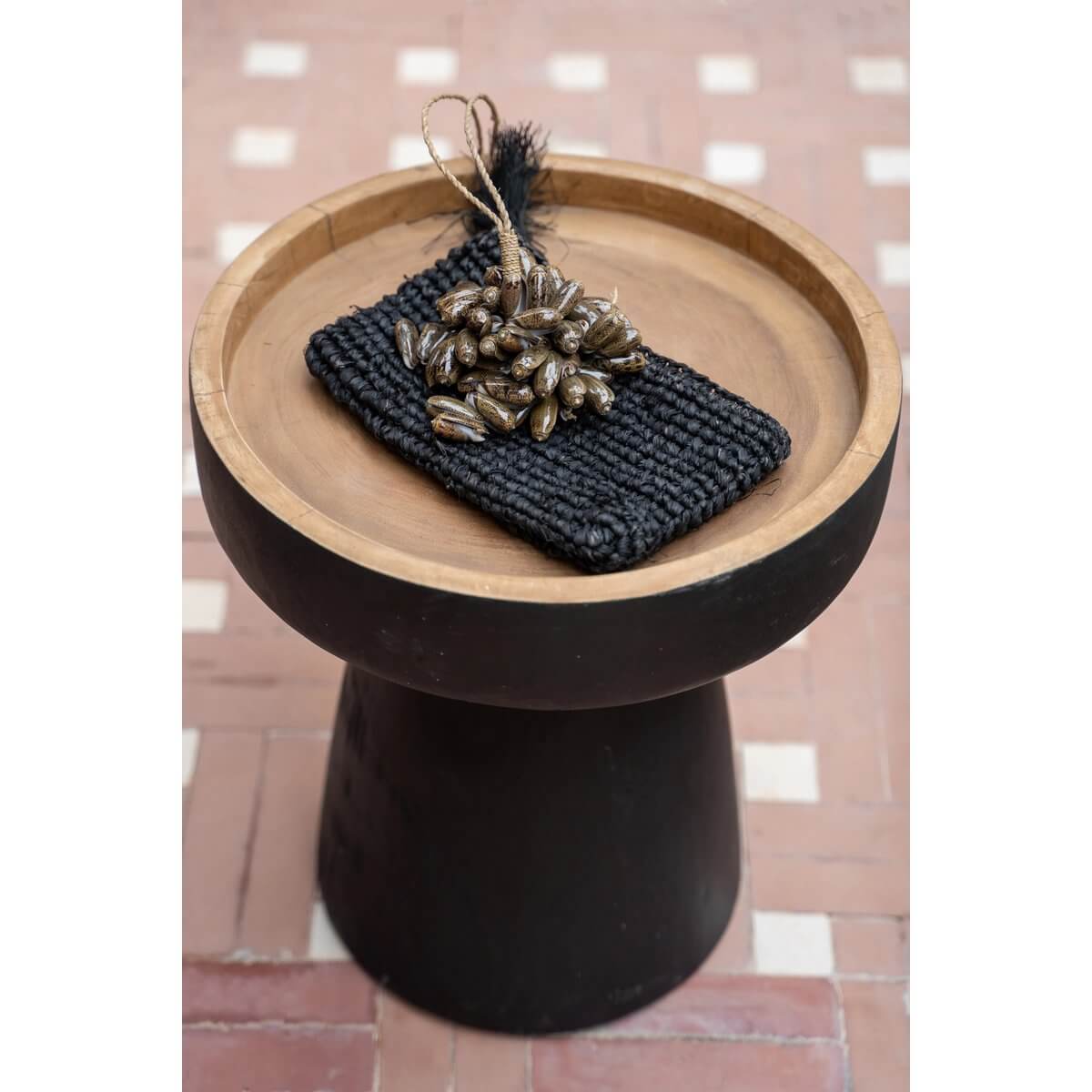De bruine kauri shell kwast on a wooden tray, handmade from shells by Balinese artisans, perfect for adding a bohemian touch to home decor.
