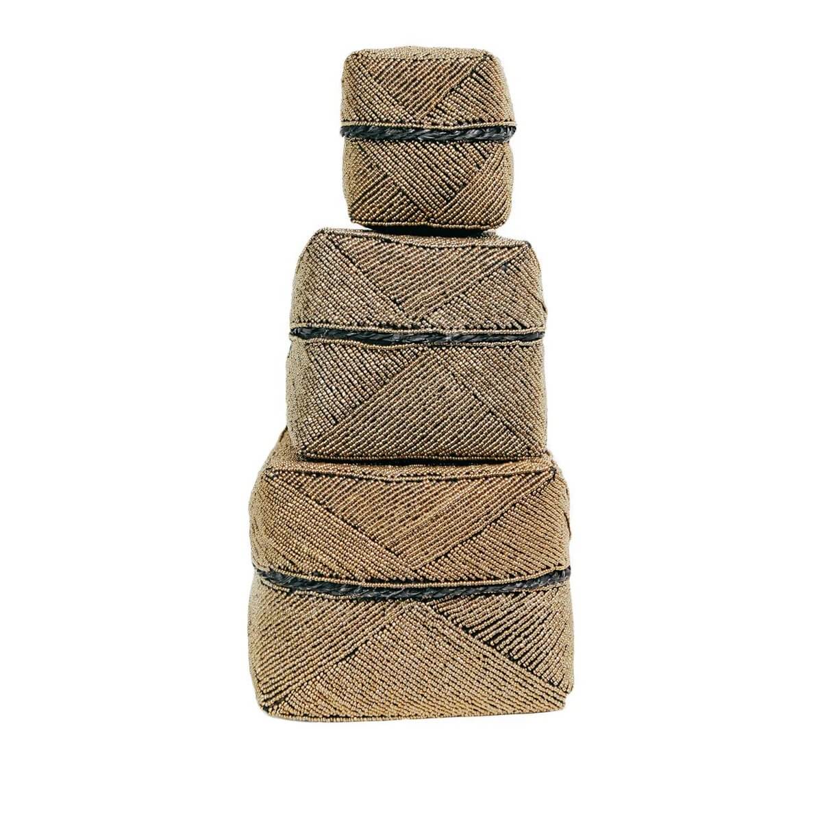Handmade Bohemian gold beaded boxes stacked in a pyramid, crafted by Balinese artisans as decorative or storage pieces.