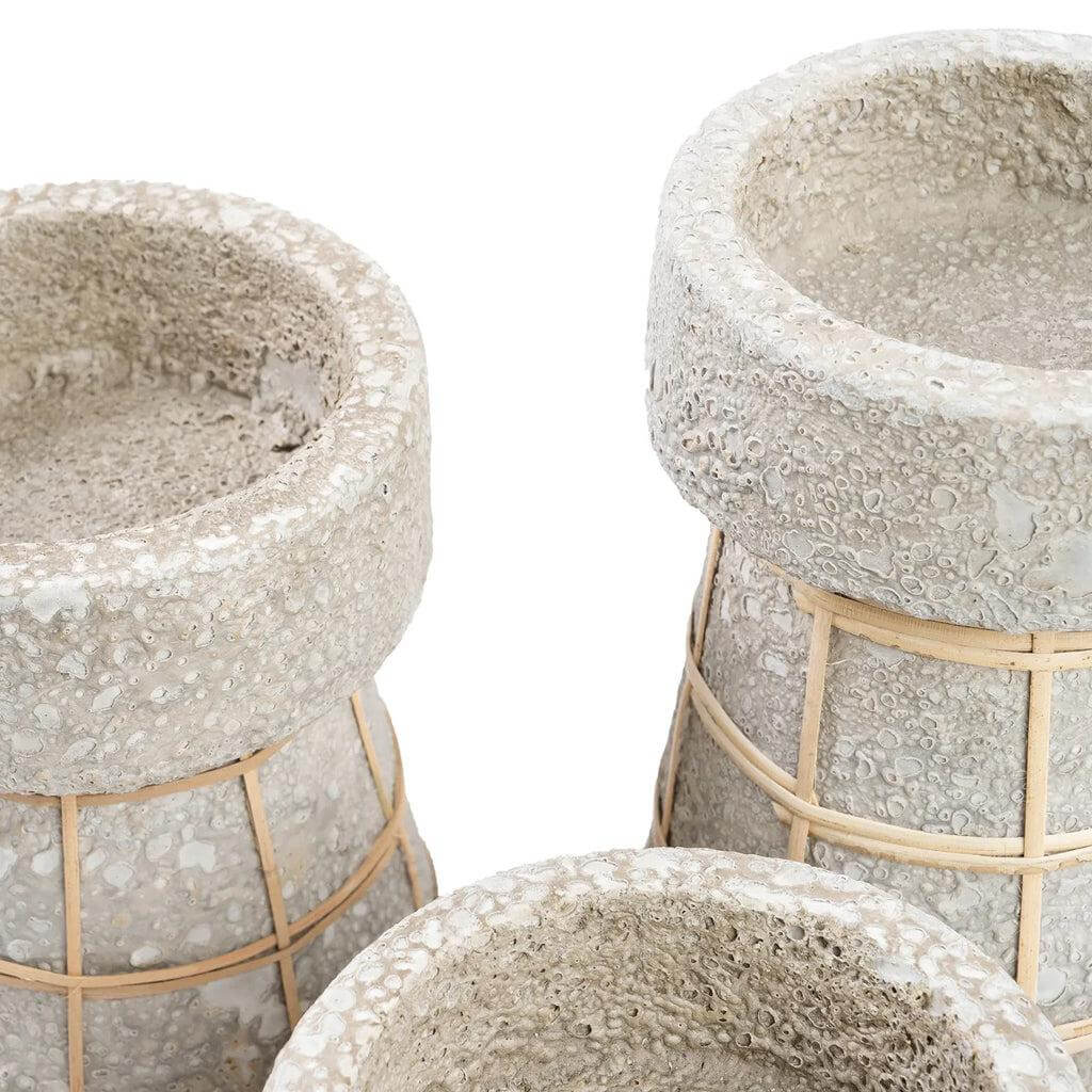 Alt Tag: Drie terracotta kaarsenhouders in betongrijs met rotan details, ideaal voor sfeervolle tafeldecoratie.