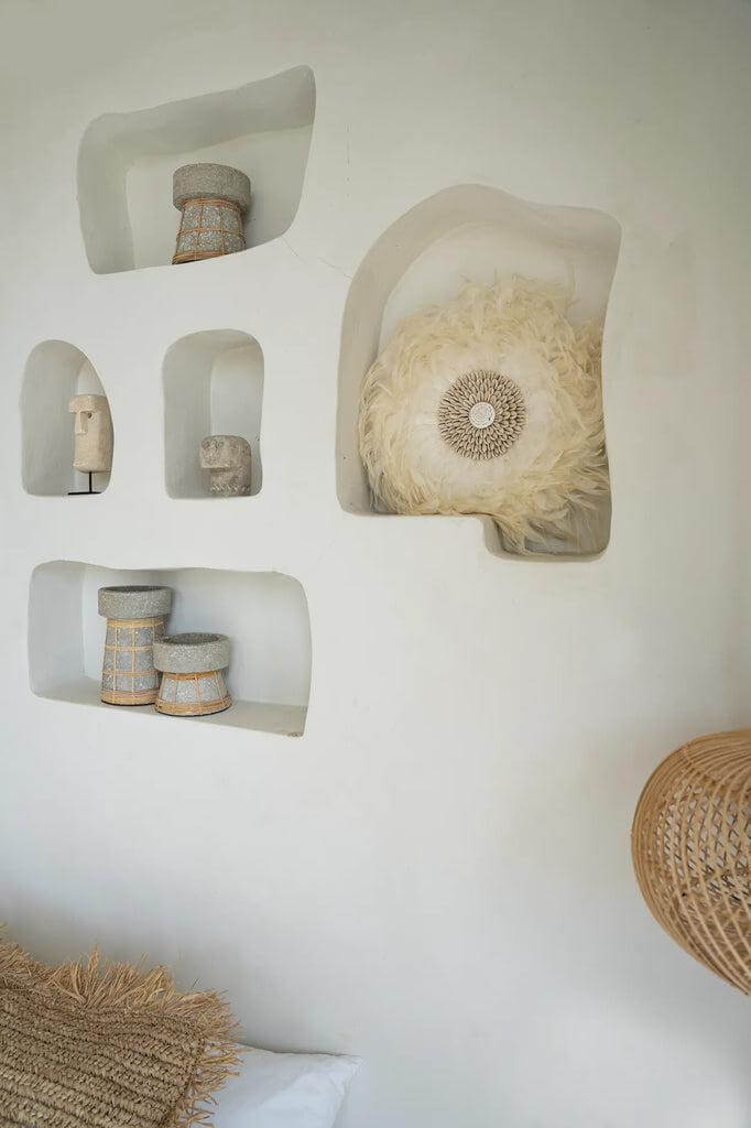 Decoratieve wandniches met rustieke manden en kunstwerken voor natuurlijke huisinrichting.