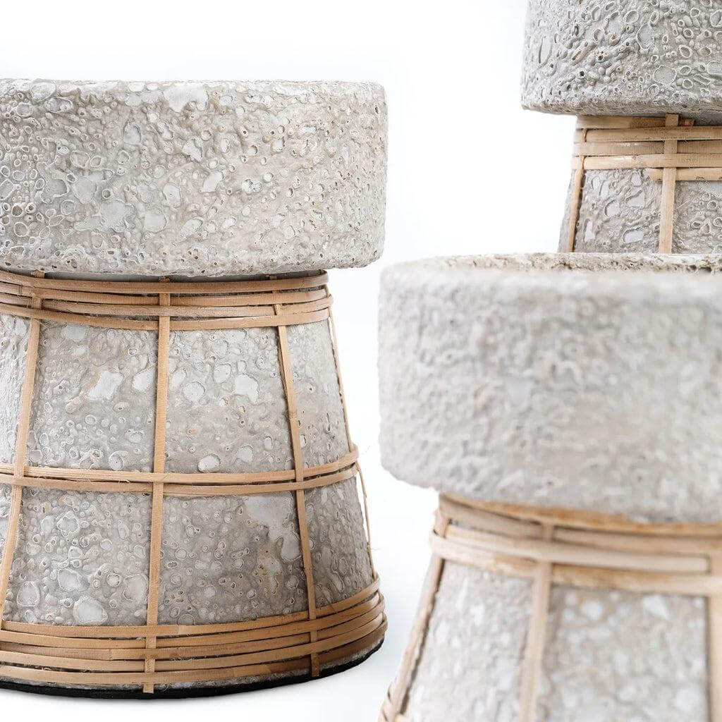 Close-up van serene betongrijze kaarsenhouders met rotan details, perfect voor sfeervolle decoratie in elke kamer.
