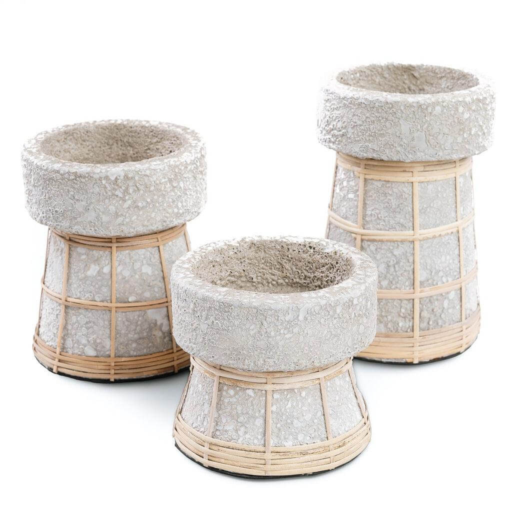 Set van drie terracotta kaarsenhouders in betongrijs met rotan details, een stijlvolle aanvulling voor elk interieur.