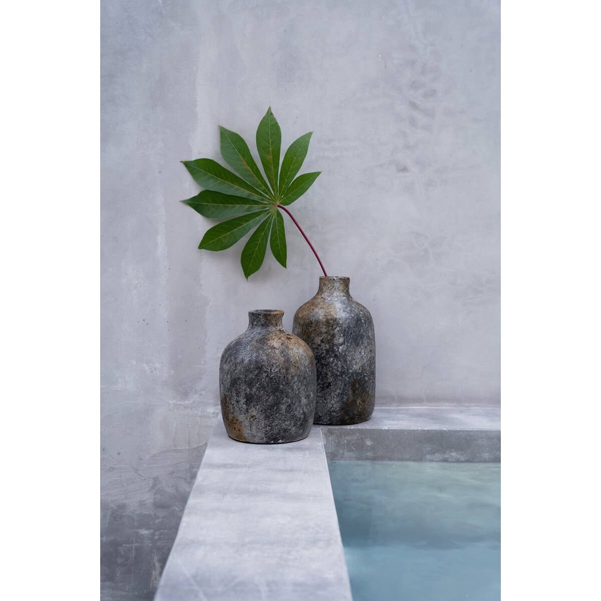 Rustic bohemian terracotta vases in antique grey with a leaf accent, adding organic elegance to home decor by Bazar Bizar Living.