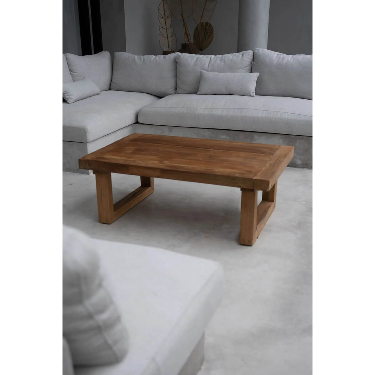 Bohemian style reclaimed teak coffee table in natural finish, accompanied by a cozy white sectional sofa.