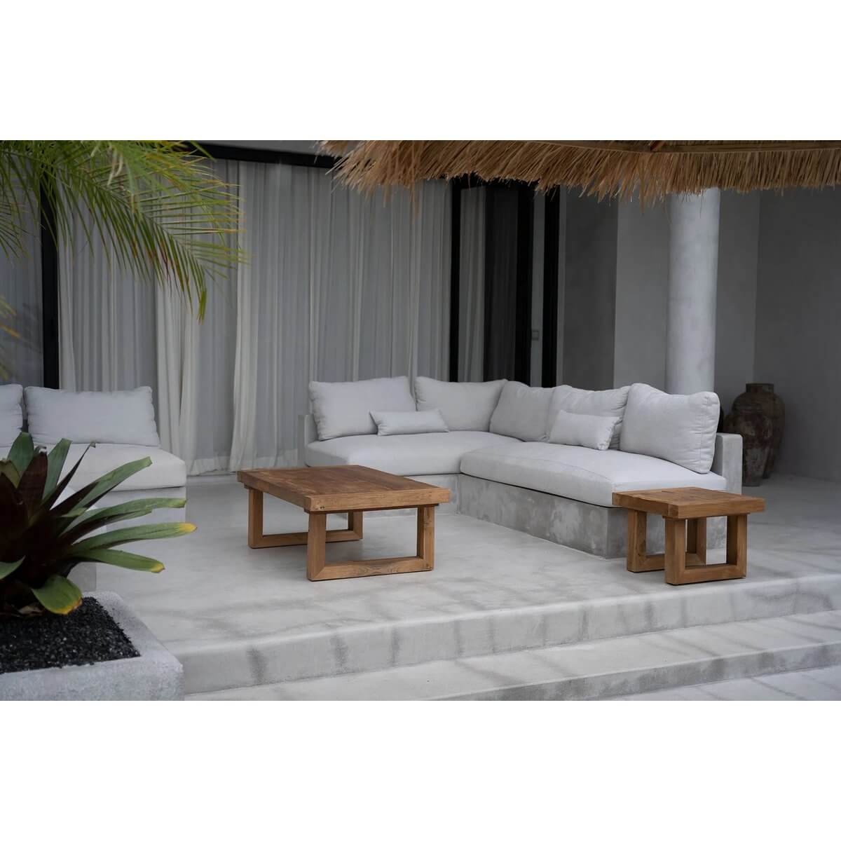 Bohemian style patio with grey sofa and reclaimed teak coffee table, creating a natural, sustainable ambiance.