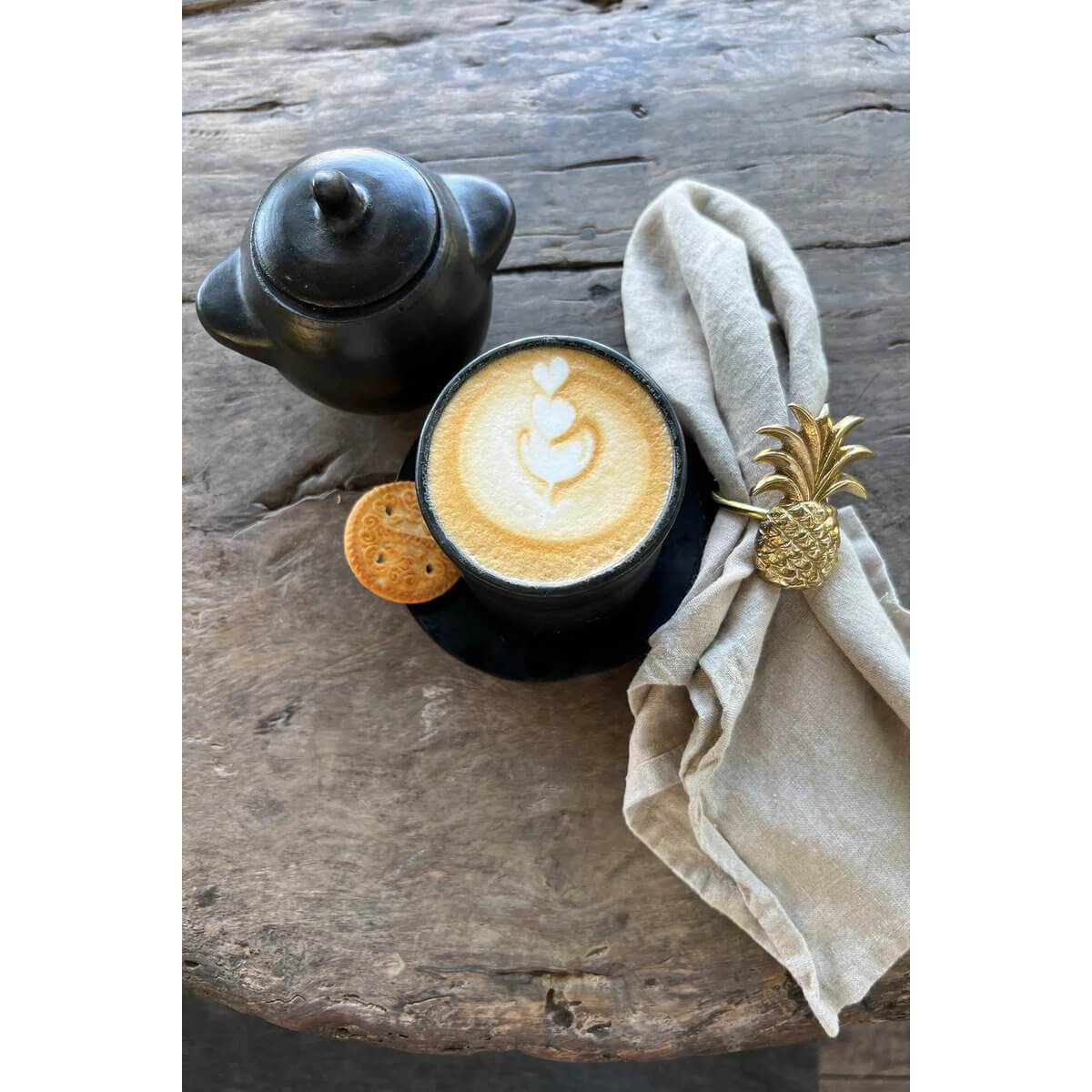 Black burnt pottery set with coffee and cookies, featuring bohemian style. Perfect for adding charm to your dining experience.