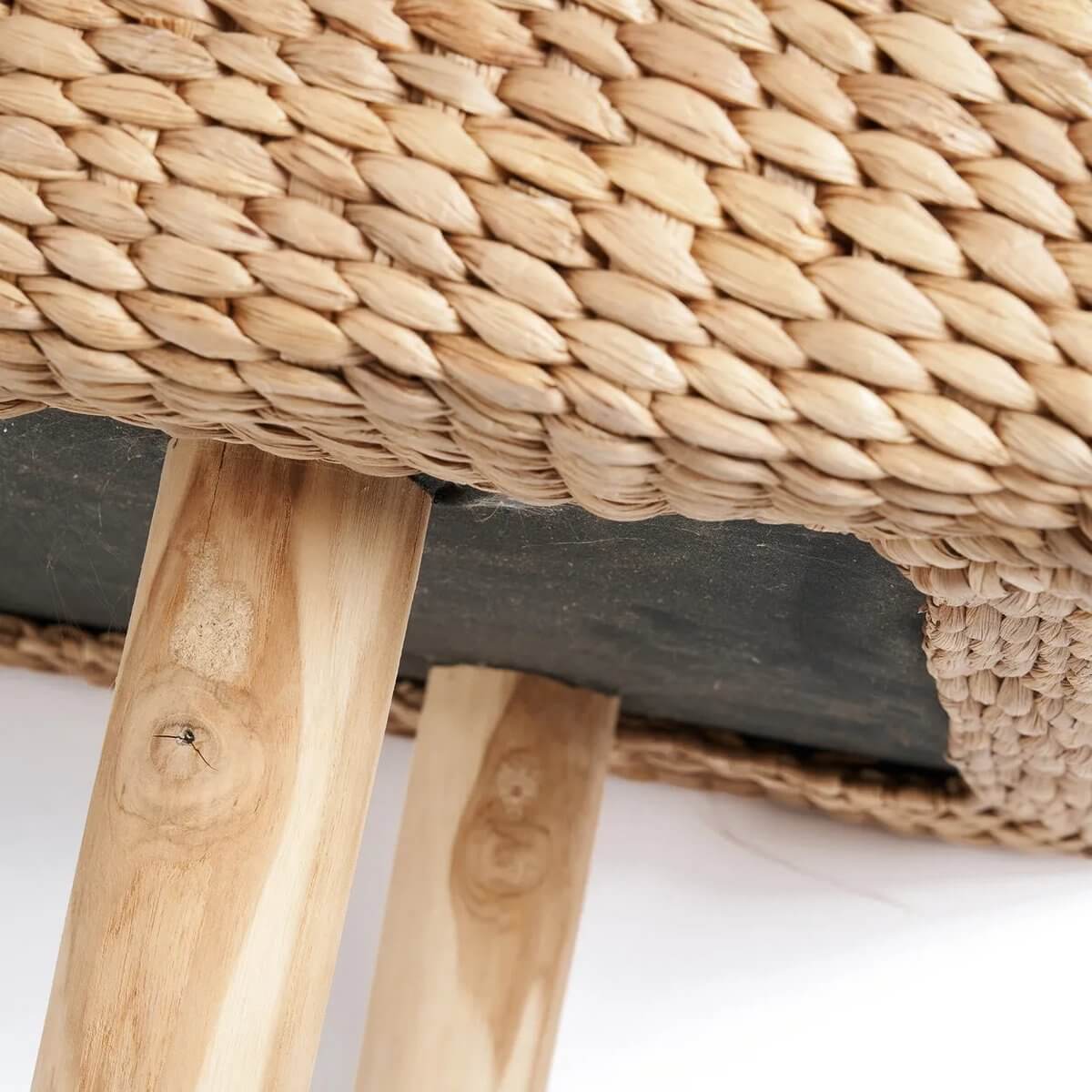 Close-up of a waterhyacinth bench with woven texture showcasing its Bohemian style and wooden legs for sustainable elegance.