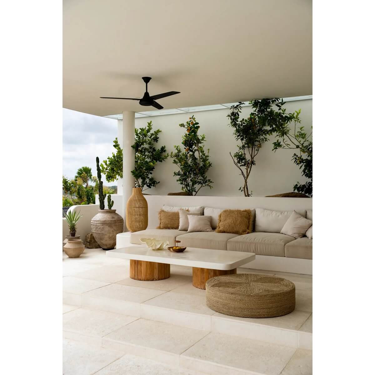 Stijlvolle woonkamer met de Zeegras Poef - Naturel, omgeven door groene planten en comfortabele zitplaatsen, boho-chic sfeer.