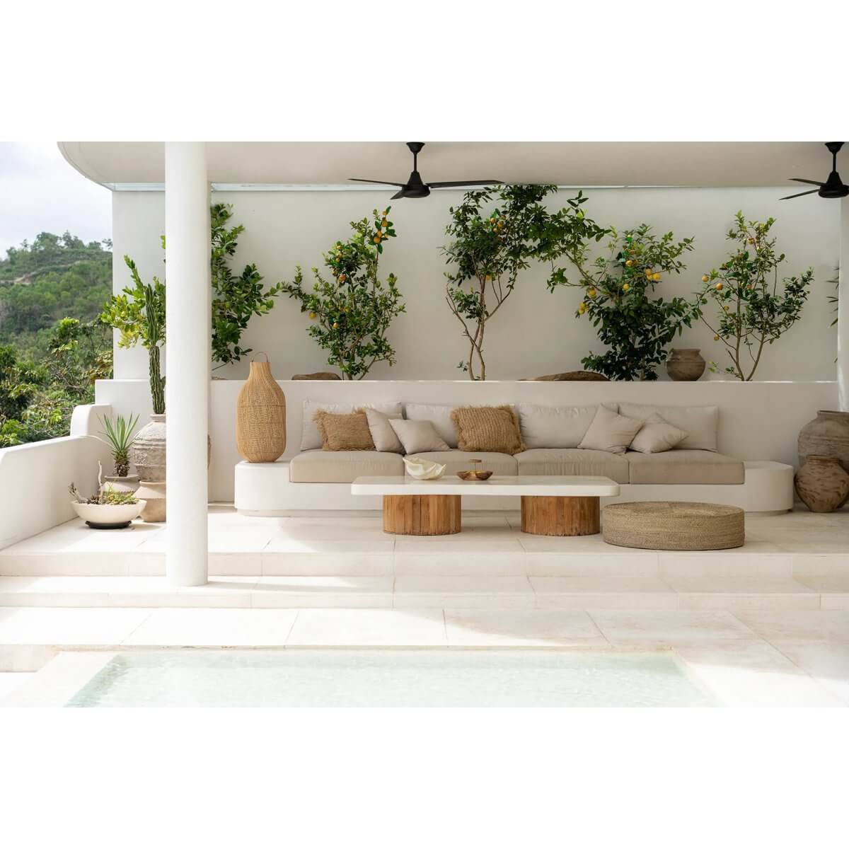 Luxe buitenruimte met moderne meubels en zeegras poef voor een stijlvolle lounge-ervaring. Inclusief natuurlijke tinten en planten.