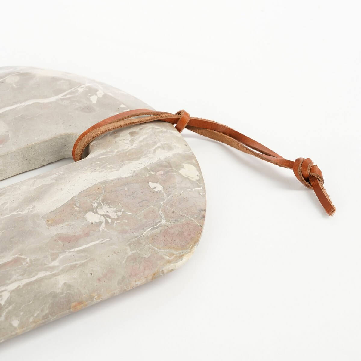 Marmeren snijplank van Mica Decorations met unieke patronen en beige tinten, inclusief leren lus voor een luxueuze keukenuitstraling.