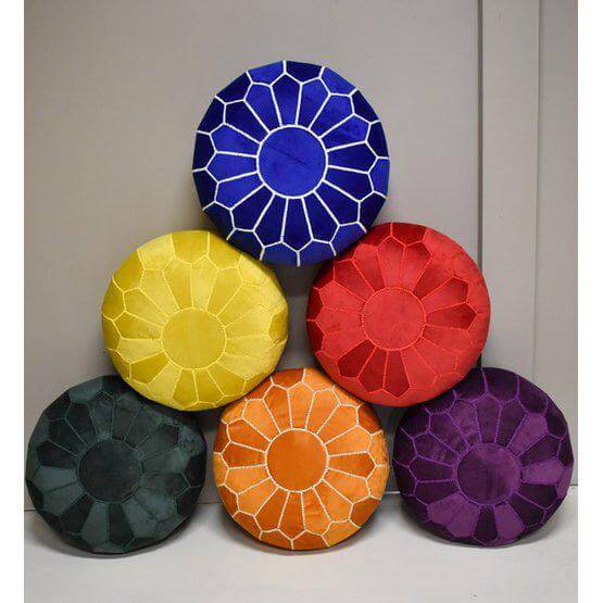 Vrolijke stapel van Marokkaanse handgemaakte fluwelen poefs in diverse kleuren, perfect voor een gezellige boho sfeer in huis.