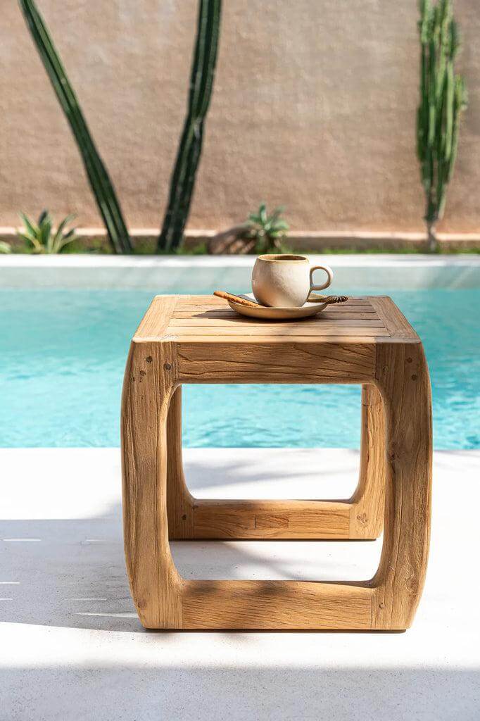 Houten bijzettafel met koffie aan het zwembad, zomerse buiten setting met groen decor