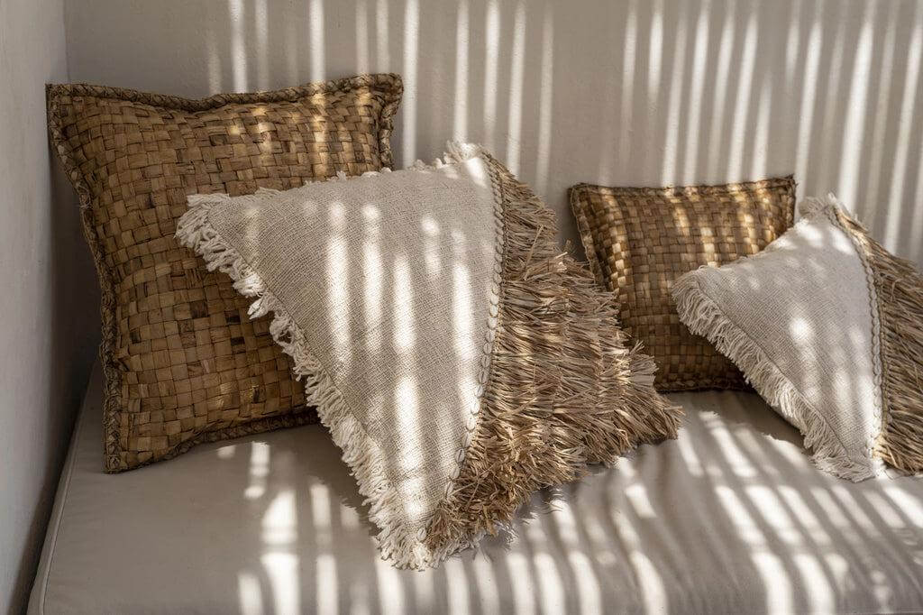 Hyacint kussen 60x60 met natuurlijke look, handgeweven waterhyacint in zacht interieur, rustieke boho stijl op een witte bank.