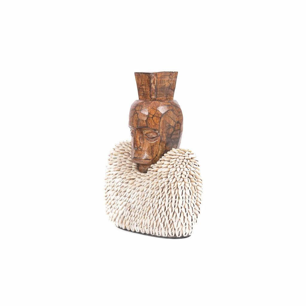 Handgesneden Ogoh Ogoh beeld uit jackfruit hout met kaurischelpen, bedoeld om kwade geesten af te weren, decoratief en cultureel Indonesisch kunstwerk.