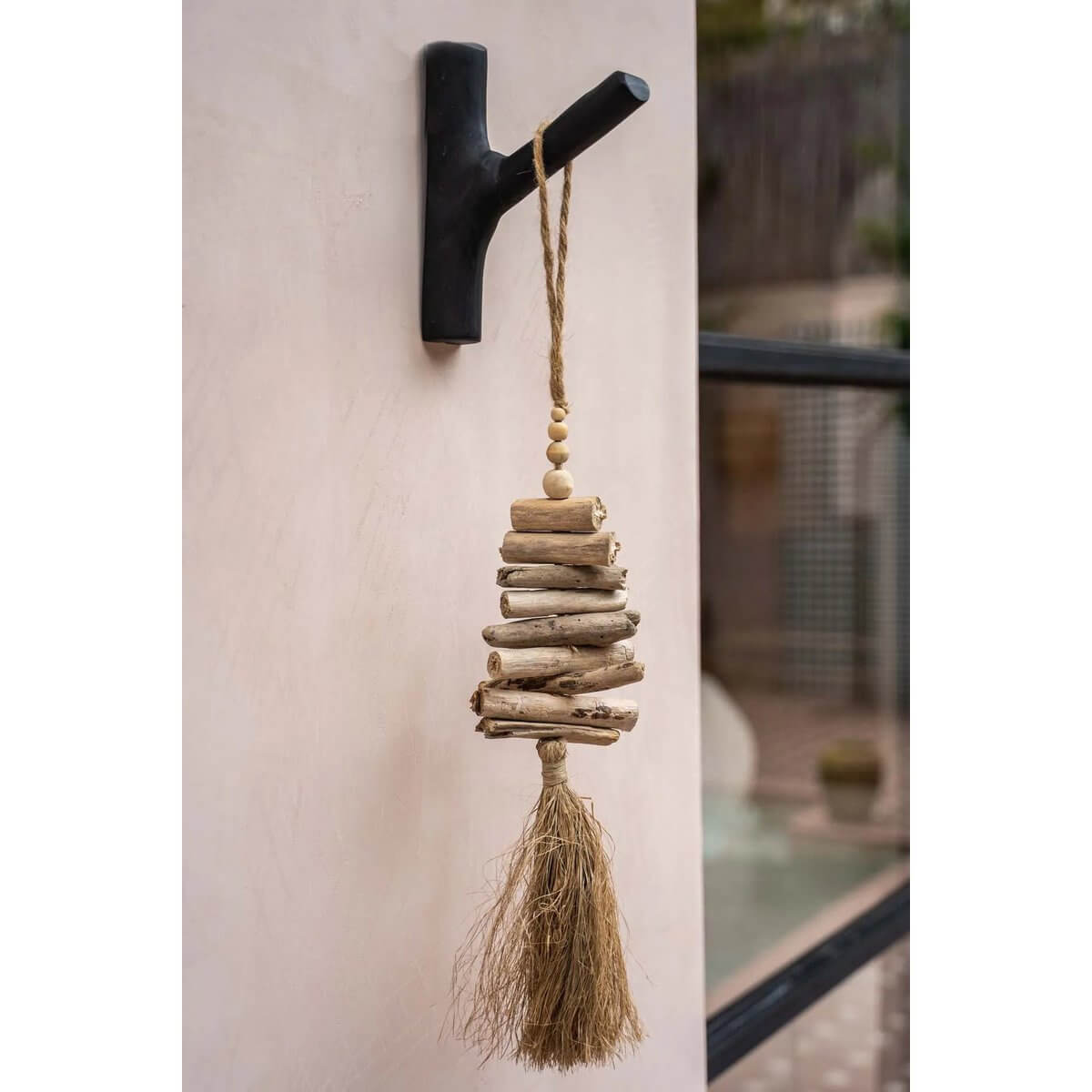 Bohemian raffia and driftwood tassel handmade by Balinese artisans, perfect for home decor on doors, curtains, or walls.
