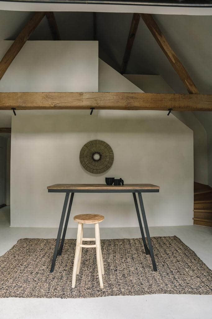 Seagrass vloerkleed in natuurlijke en zwarte tinten met houten barkruk, ideaal voor keuken of woonkamer, 180x240 cm.