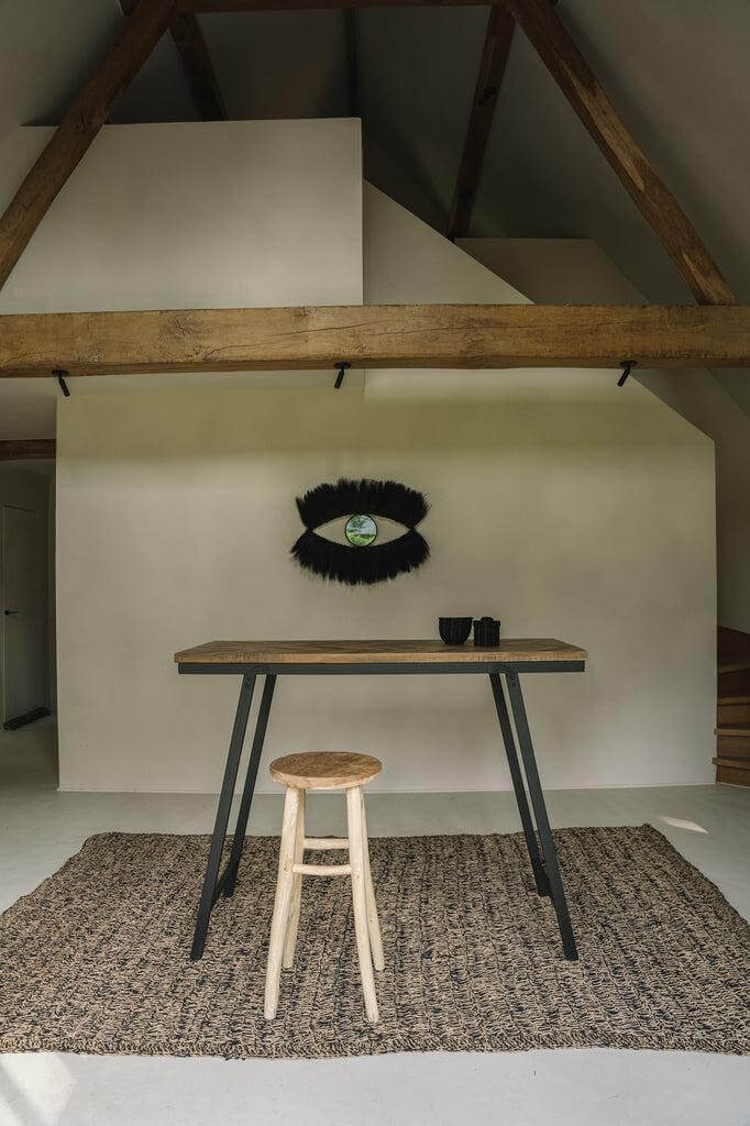 Moderne ruimte met zeegras tapijt, houten kruk en minimalistische tafel in natuurlijke en zwarte kleuren