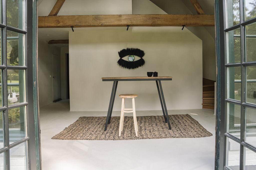 Moderne kamer met rechthoekig natuurlijk zwart zeegras tapijt, tafel en stoel, benadrukt rustieke en natuurlijke texturen.