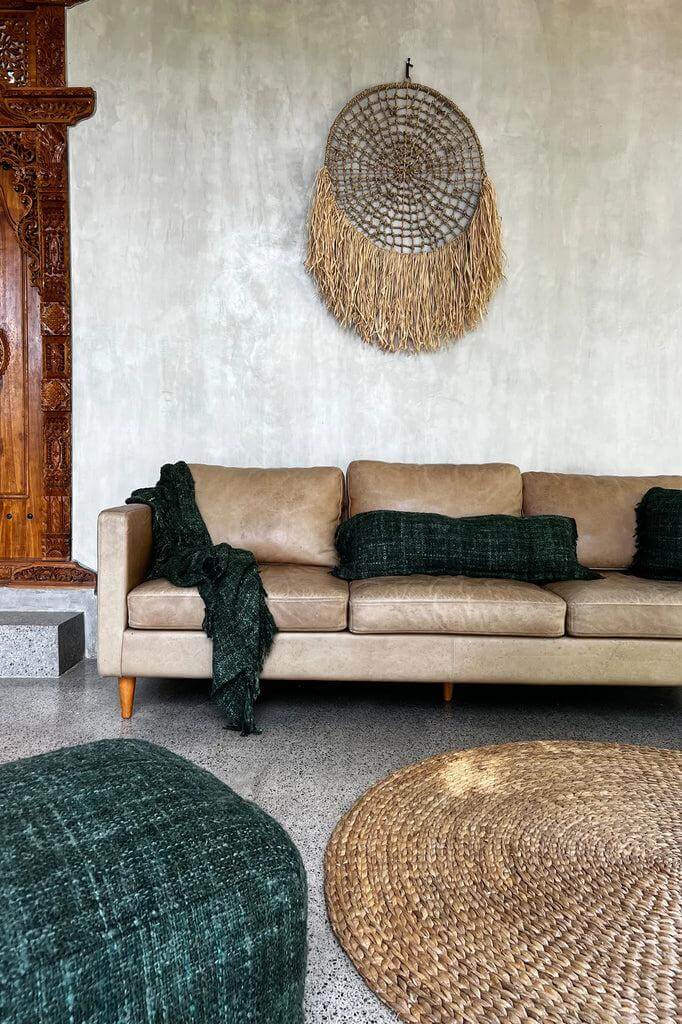 Alt Tag: Boho woonkamer met waterhyacint tapijt en natuurlijke decoratie tegen een achtergrond van beige bank en groene accenten.