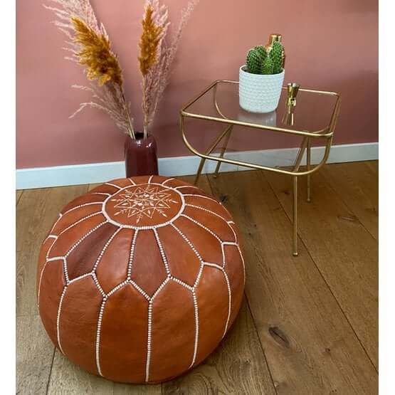 Leren poef terrabruin in woonkamer met boho interieur, handgemaakte Marokkaanse poef als voetenbankje of extra zitplaats. Gezellig en multifunctioneel!